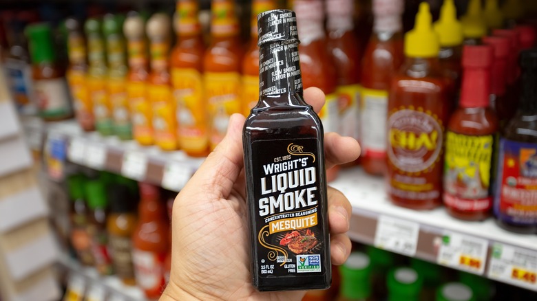 Hand holding bottle of liquid smoke